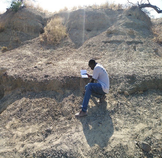Sylvester Musembi Musyoka, a Kenyan colleague and field crew leader, recording a large mammal fossil bone during a virtual field project to collect fossils in Kenyan excavation sites that were in danger of being damaged by severe weather. (Nzioki Mativo/Smithsonian)
