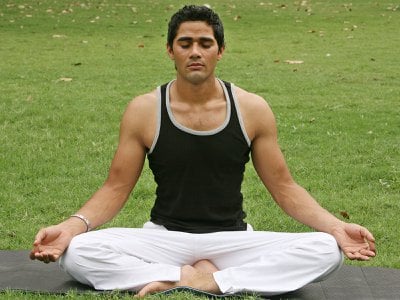 A yoga instructor practices a breathing exercise.