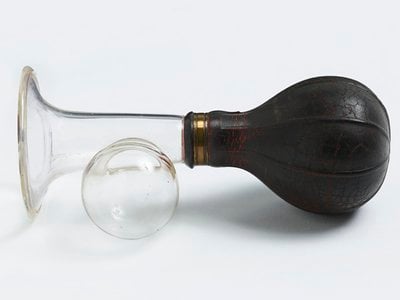 Manual breast pump with black bulb, dating to sometime between 1920 and 1959