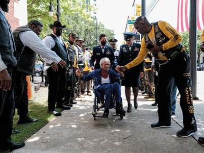 Six Triple Eight veteran Romay Johnson Davis gets handshakes and fist bumps from members of the Buffalo Soldiers Motorcycle Club in Montgomery, Alabama, in July 2022.