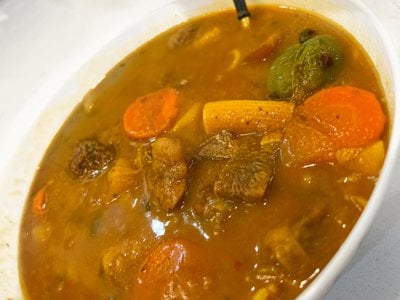 Soup joumou is a savory, orange-tinted soup that typically consists of calabaza squash, beef, noodles, carrots, cabbage, various other vegetables and fresh herbs and spices.